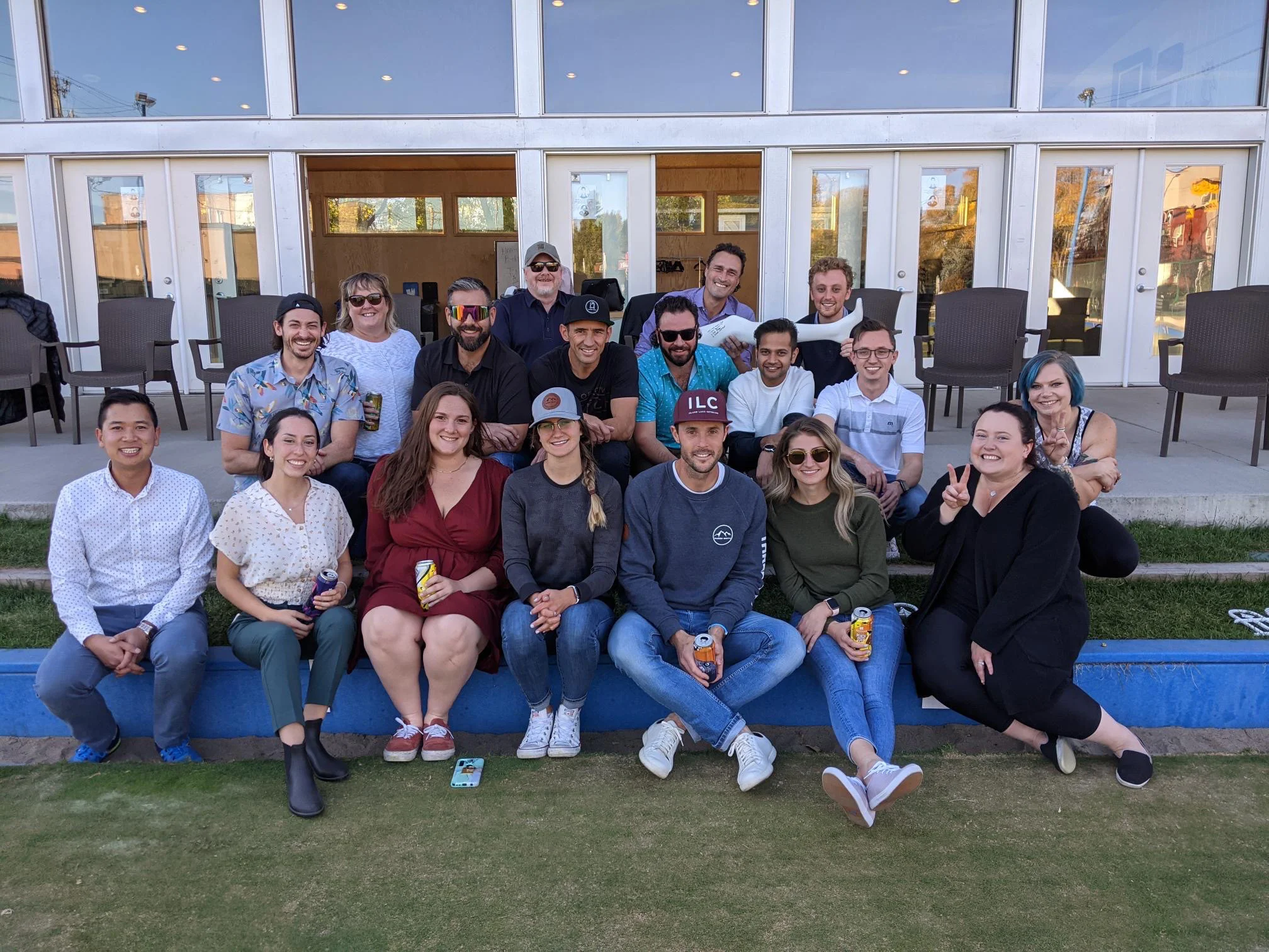 A group photo of the 360 team at a company event. The photo shows 18 people grouped together in 3 rows. The photo was taken at a lawn bowling tournament.